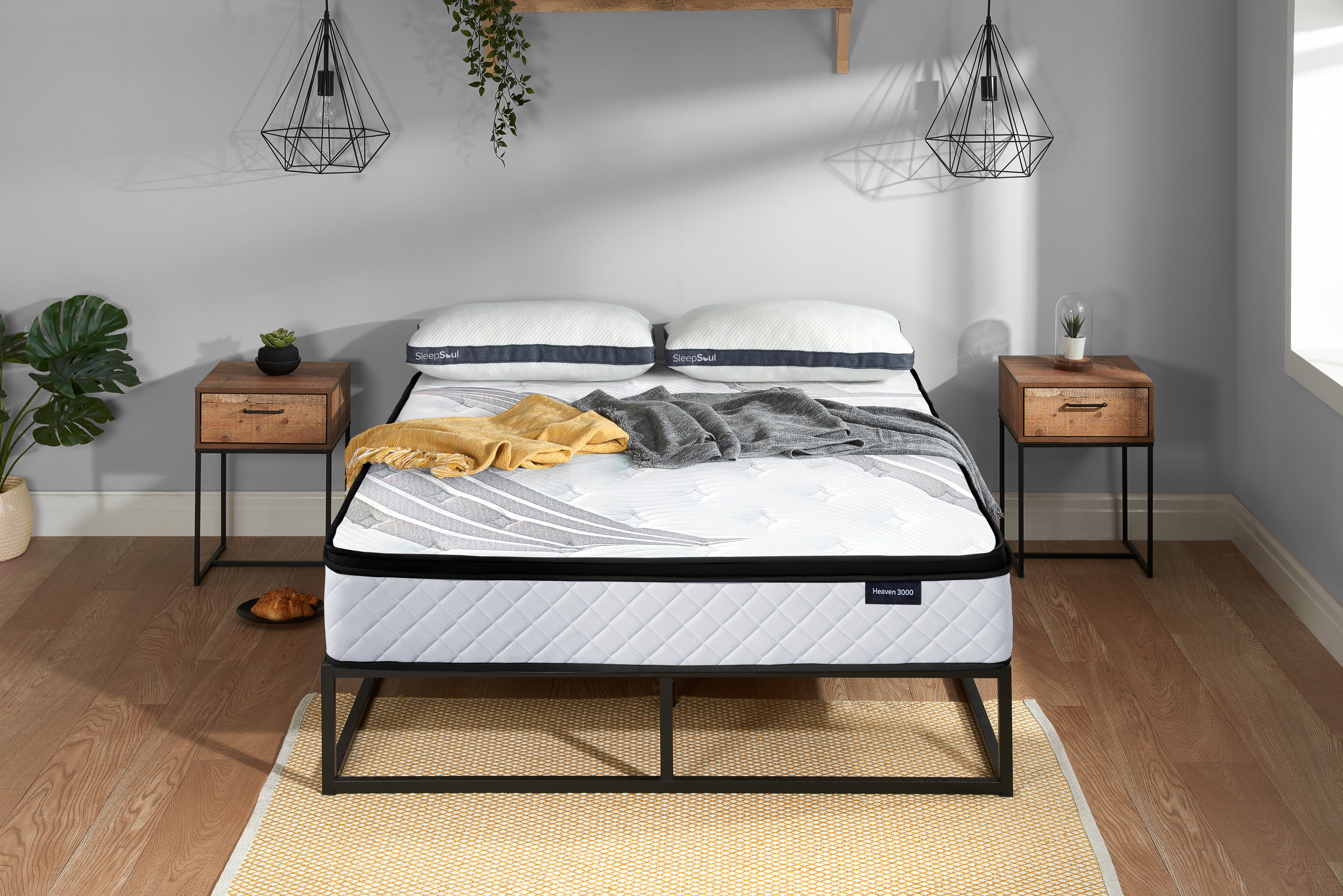 SleepSoul Heaven 3000 pocket spring mattress on a metal bed frame in minimalist bedroom with two side tables and straw rug