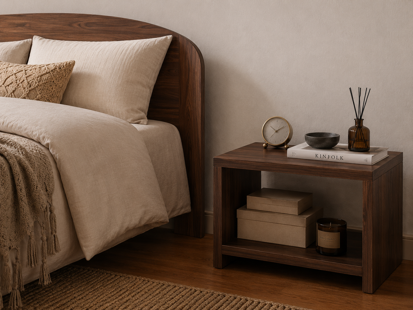 A walnut finish wooden nightstand in a bedroom setting, styled with a small clock, a bowl, a reed diffuser, and stacked boxes on its open shelf.
