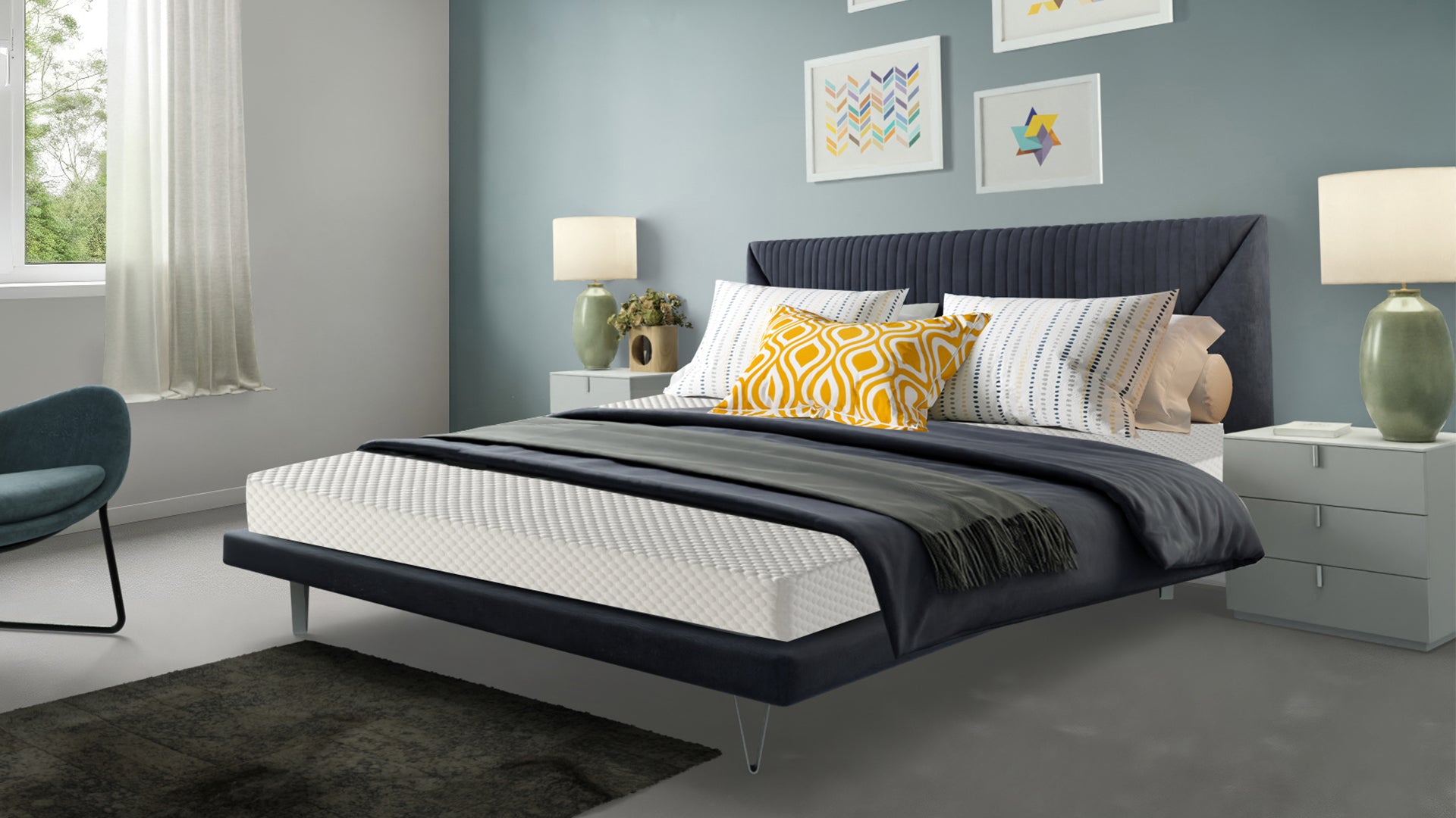 Komfi Unity Comfort mattress on velvet bed frame with white, black, grey and yellow bedding, with white bedside drawers and sage green ceramic lamps in modern bedroom